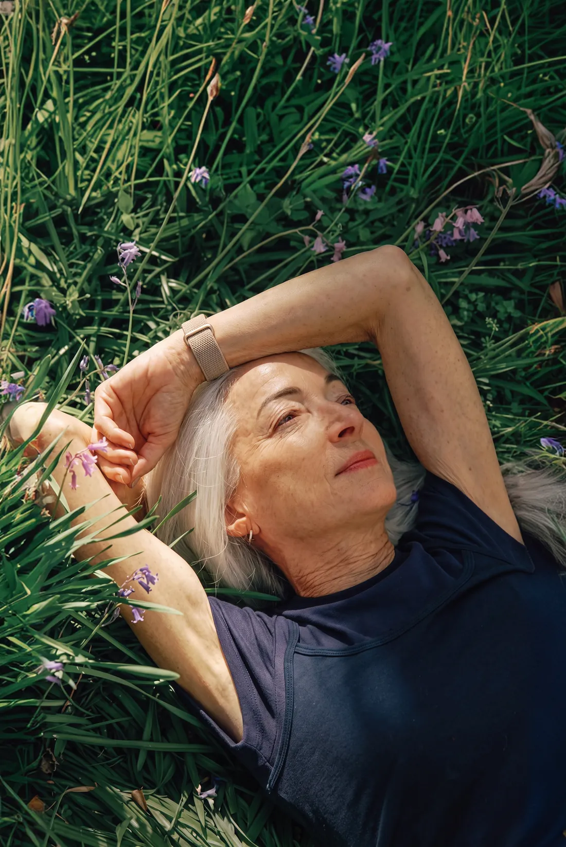 A woman lying in the grass, looking up